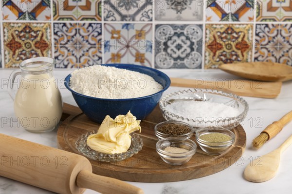 Baking ingredients, flour, butter, spices on wooden board in kitchen, with decorative tiles in
