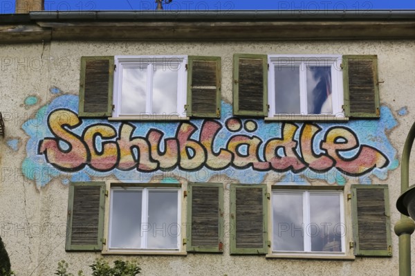 Clothes shop and meeting café Schublädle, mural, house facade, writing, social project, second-hand
