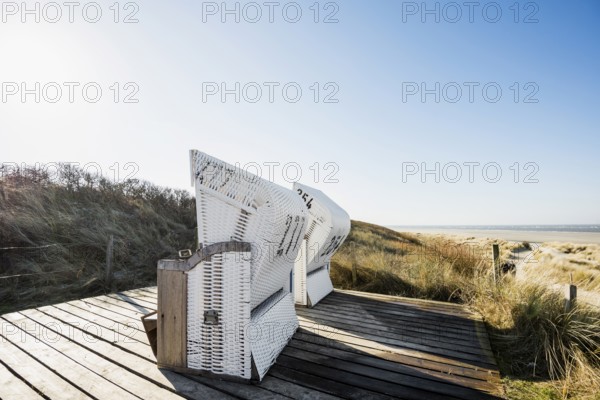 Beach chairs in the dunes and blue sky in winter, Spiekeroog, East Frisian Islands, Lower Saxony,