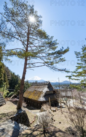 Iyashinosato open-air museum, old Japanese village with traditional houses, at the back volcano Mt.