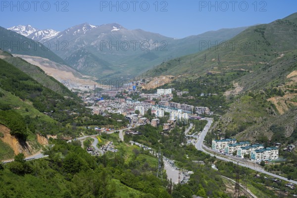 View of a city in a valley surrounded by mountains and green landscapes, view of Qajaran, Kajaran