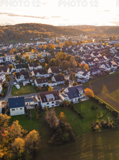 Near settlement with autumn trees and roofs, illuminated by golden sunlight, Aidlingen, Böblingen