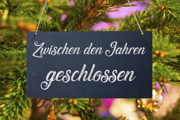 (Photo montage) Christmas holidays: sign with the inscription CLOSED BETWEEN THE YEARS in front of