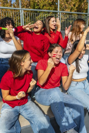 Group of diverse young women showing enthusiasm and support while attending a sports event,