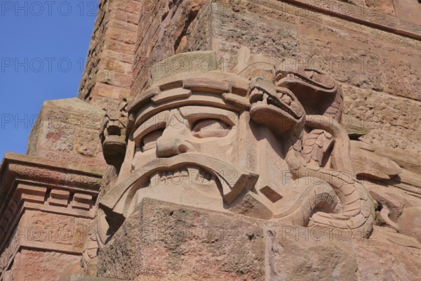 Warrior's face with snake figure and dragon at the Kyffhäuser monument, detail, figure, stone, red,