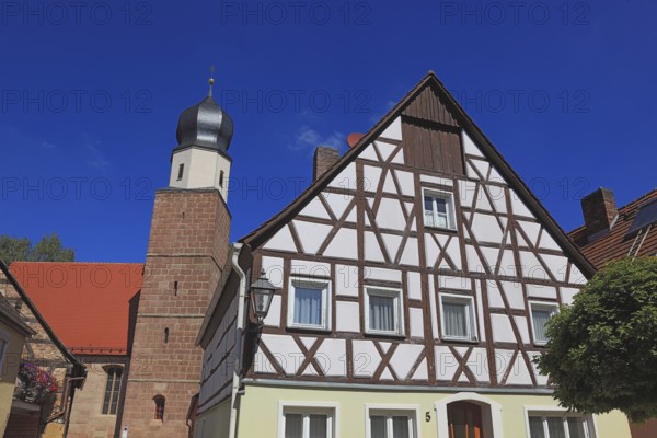 Half-timbered house and tower of the Catholic Church, town of Heideck in the district of Roth,
