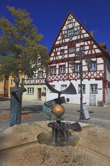 Half-timbered houses and fountain figure flute player, on Rathausplatz, city of Heideck in the