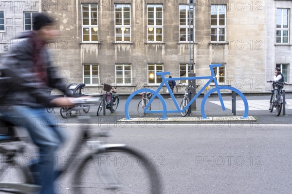 Bicycle parking spaces, with so-called leaning bars and a large blue bicycle silhouette, to make