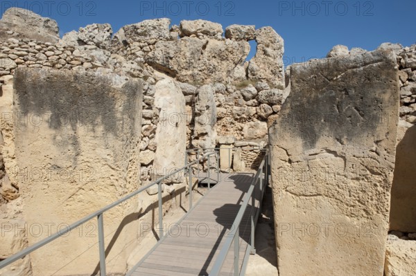 View from secured walkway with railing through ruins remains of Ggantija temple, UNESCO World