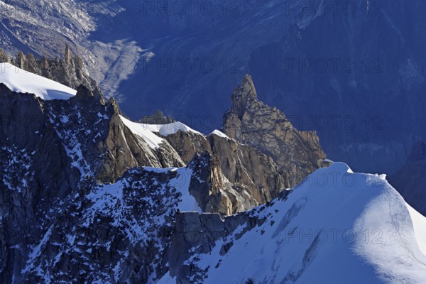 Rugged rocks jut out of a snow-covered mountain, viewing platform, Aiguille du Midi mountain