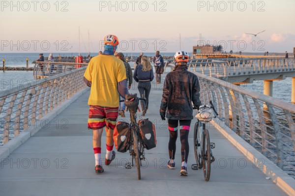 Tourists on the new 720-meter long pier in Prerow in the evening light, open since October 2024,