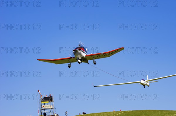 A Robin DR 400/200R Remorqueur light aircraft, registration D-EFGH, tows a glider during a flight