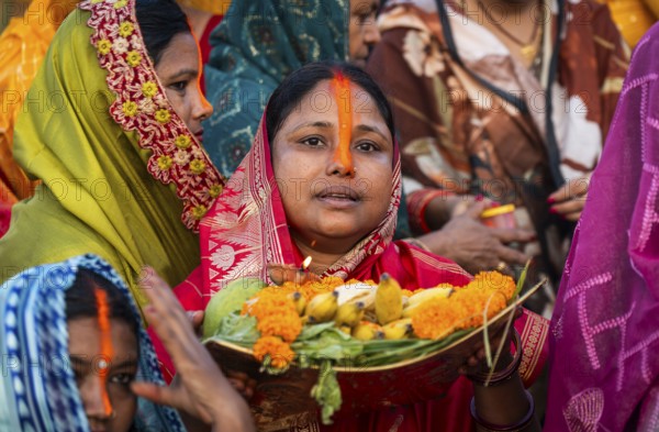 Hindu devotees offer prayers to the Sun God on the bank of Brahmaputra river on the occasion of
