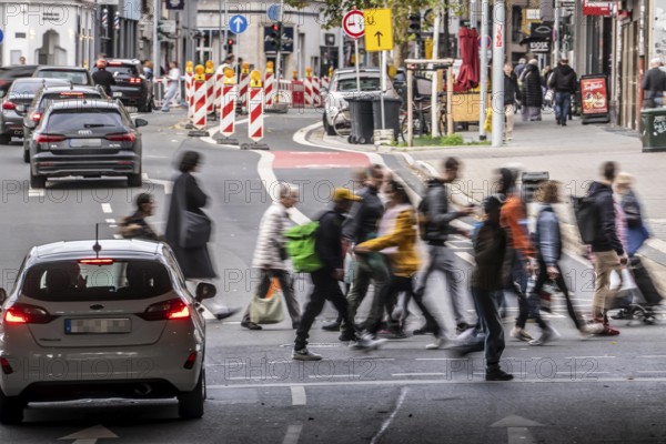 Pedestrians at Düsseldorf-Bilk train station, cross Friedrichstraße at a pedestrian crossing with