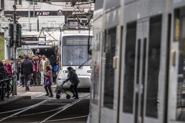 Pedestrians cross the tram tracks, at Düsseldorf-Bilk station, junction of S-Bahn, subway, tram,