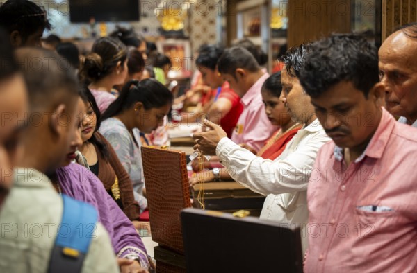 Customers purchase Gold jewelry at a store on the occasion of the festival of Dhanteras, in