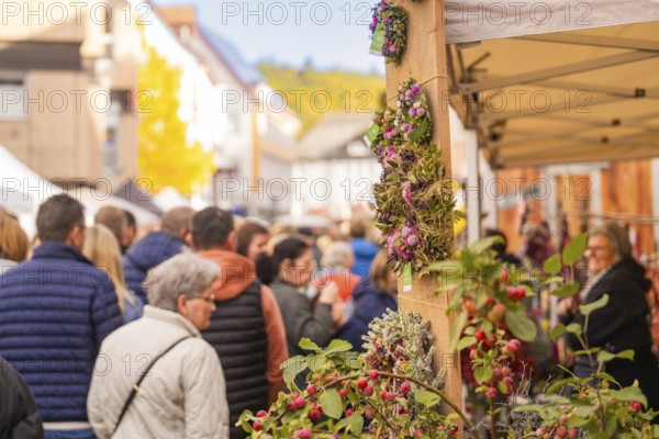 Busy shopping street in autumn, people strolling between modern buildings and colorful shops,
