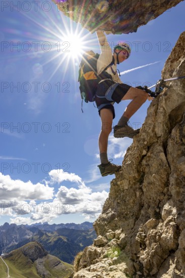 Mountaineer climbs on Ferrata Furcela de Saslonch, Langkofelscharte via ferrata, Dolomites,