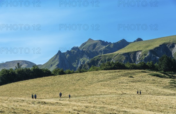 Auvergne Volcanoes Regional Park. Groups of hikers traverse a rugged path in the beautiful Sancy
