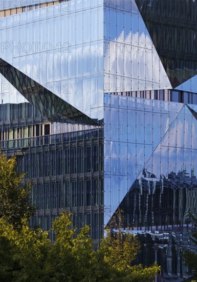 Cube Berlin, cube-shaped office building with folded glass façade reflecting the surroundings,