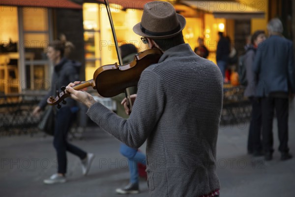 Italy, street musician entertaining tourists near landmark Florence attraction of Il Duomo
