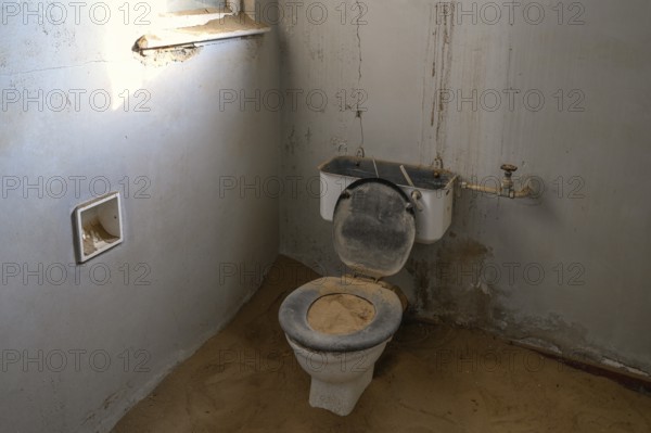 Toilet full of sand in the former hospital, Kolmanskop, restricted diamond area, Karas region,
