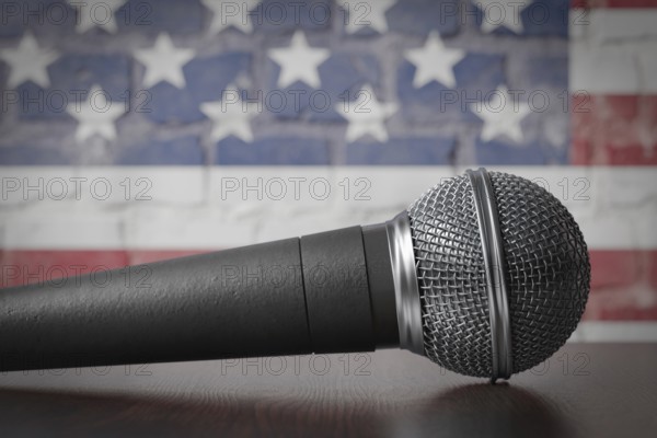 Microphone resting on a table with the american flag painted on A brick wall behind