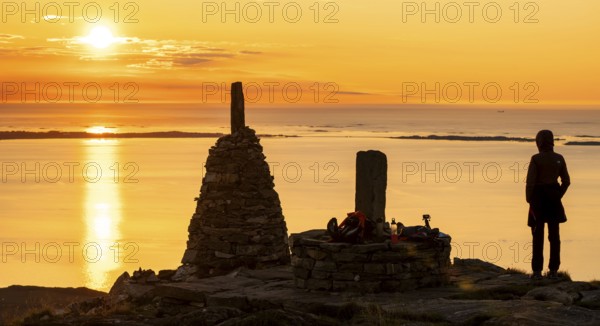Silhouette of a woman watching the sunset next to cairns, Rørsethornet stone staircase, with 3292