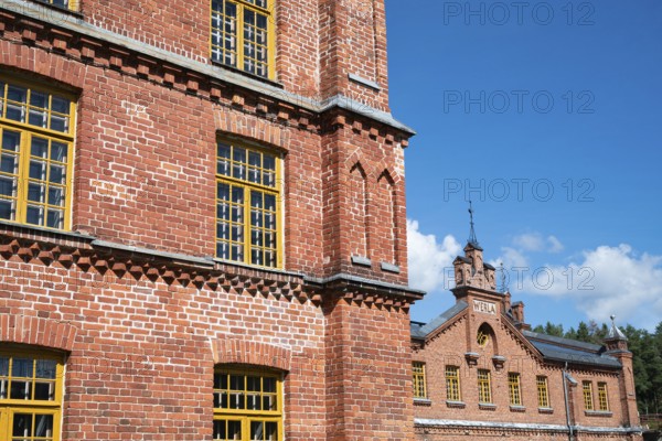 Brick façade with yellow windows, former paper factory and mill for the production of groundwood