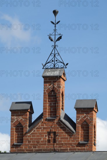 Iron ornamental element on roof peak, brick gable, former paper mill for the production of