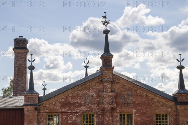 Brick building with weather vane and chimney, former paper mill for the production of groundwood