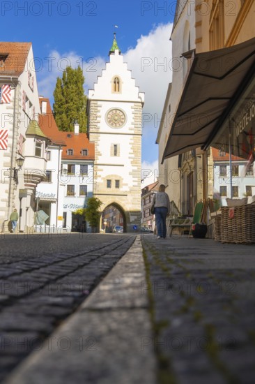 View through an alley to a historic Tor tor under a blue sky with clouds, Überlingen, Lake