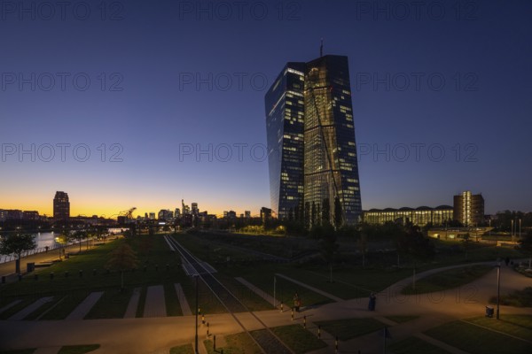The lights of the European Central Bank (ECB) and the Frankfurt banking skyline glow in the