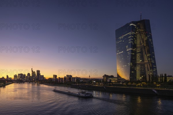 A boat cruises along the Main at sunset, in front of the European Central Bank (ECB) and the