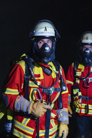 Firefighter with breathing apparatus in the dark, concentrated and ready for action, firefighting