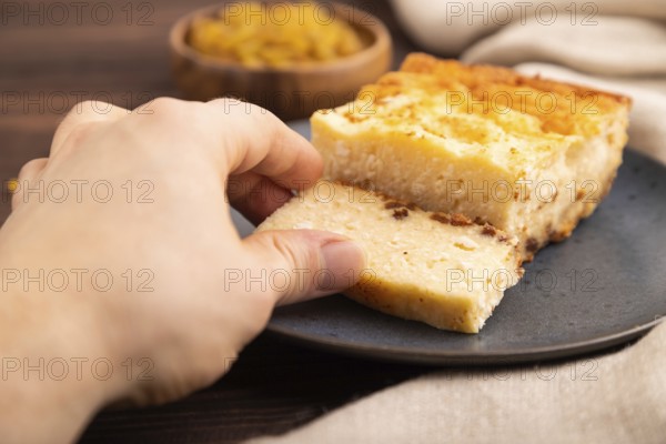 ?ottage cheese ?asserole, Curd cake, with dried apricots and raisins with hand on brown wooden