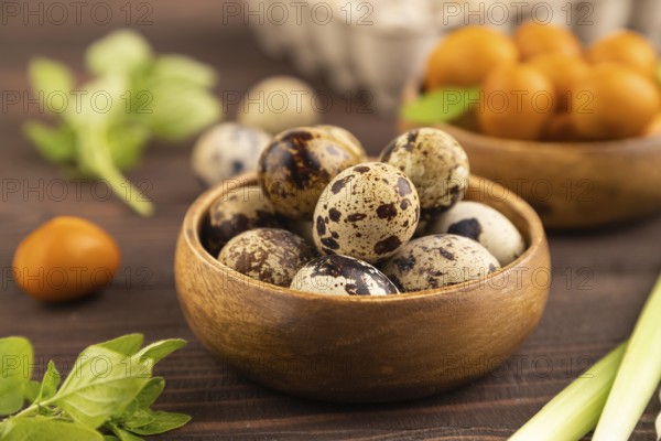 Pile of Smoked Quail eggs in bowl on a brown wooden background. side view, close up, selective