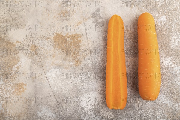 Orange Carrot on brown concrete background. Top view, copy space, flat lay. healthy food,