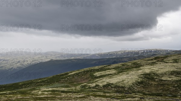 Vast mountain landscape with patches of snow and a cloudy atmosphere, pilgrimage route Olavsweg or