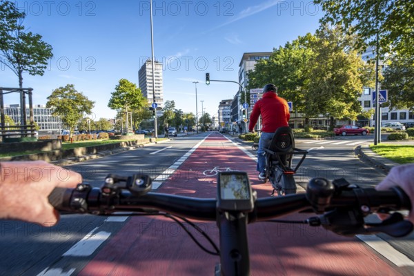 Riding a bike in a bike lane, marked in red to attract the attention of motorists, between 2 lanes,