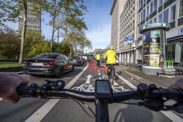 Riding a bike in a bike lane, marked in red to attract the attention of motorists, between 2 lanes,