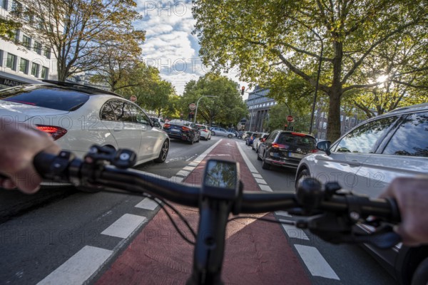 Riding a bike in a bike lane, marked in red to make drivers aware of the bike lane, between 2