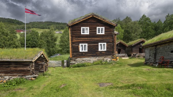 Norwegische Holzhäuser mit Gras auf den Dächern, Fahnenmast mit Norwegen-Flagge, historischer