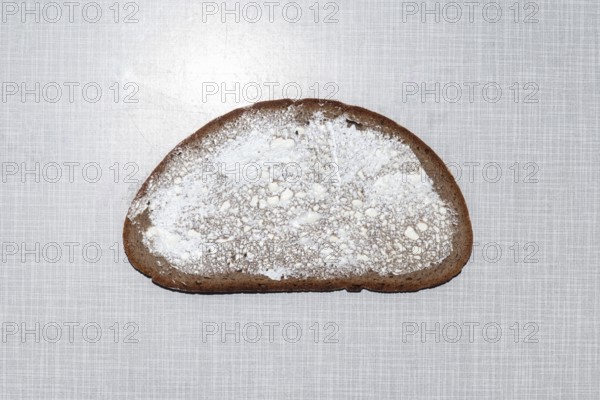 Top shot of a slice of bread smeared with margarine on a white Resopal plate