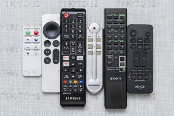 Top shot of a series of remote controls on a white Resopal panel