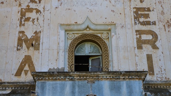 Lost Place, Nahaufnahme der Fassade mit Bröckelstellen und verblassten Schriftzügen über einem