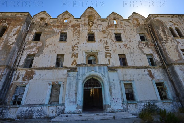 Lost Place, Verfallene Fassade eines Gebäudes mit verblassender Schrift und architektonischen
