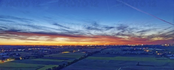 Panorama der Hamburger Vier- und Marschlande bei Nacht. Im Hintergrund die beleuchtete Silhouette