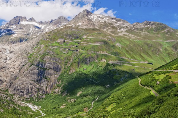 View of Furka pass road Alpine pass with tight bends hairpin bends on steep mountain slope above