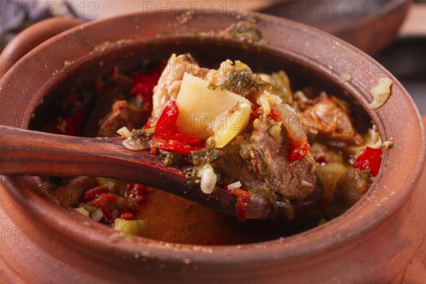 Chanakhi, a Georgian dish. in a clay pot, on a wooden table, stewed meat with vegetables, homemade,